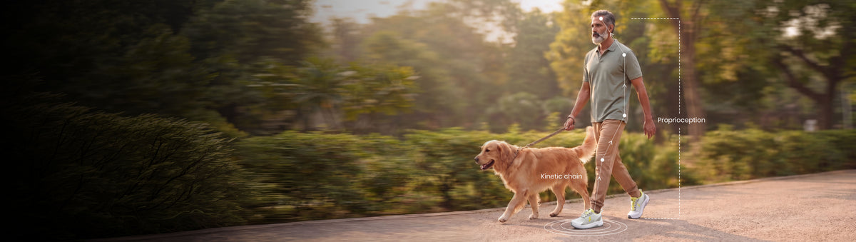 Man walking his golden retriever on a tree-lined path, with gait and stride tracking graphics overlaid near his feet, wearing Silwer Active shoes