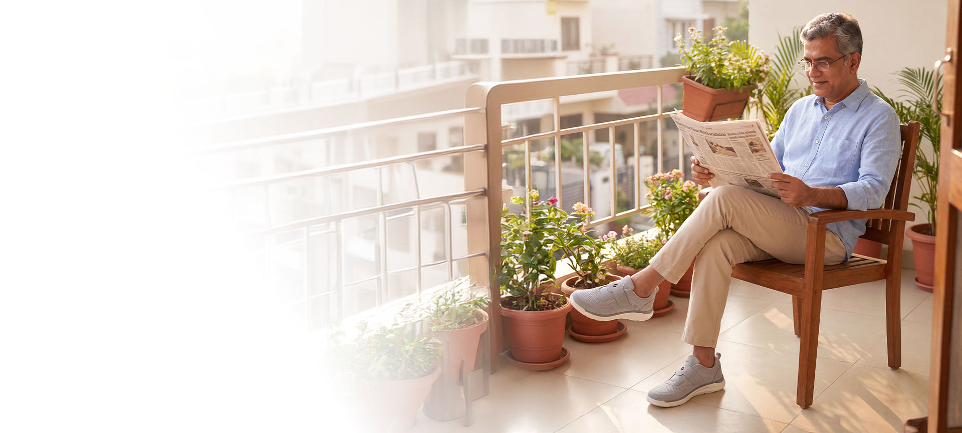 Man reading the newspaper on a home balcony wearing Silwer Ease Castle grey walking shoes