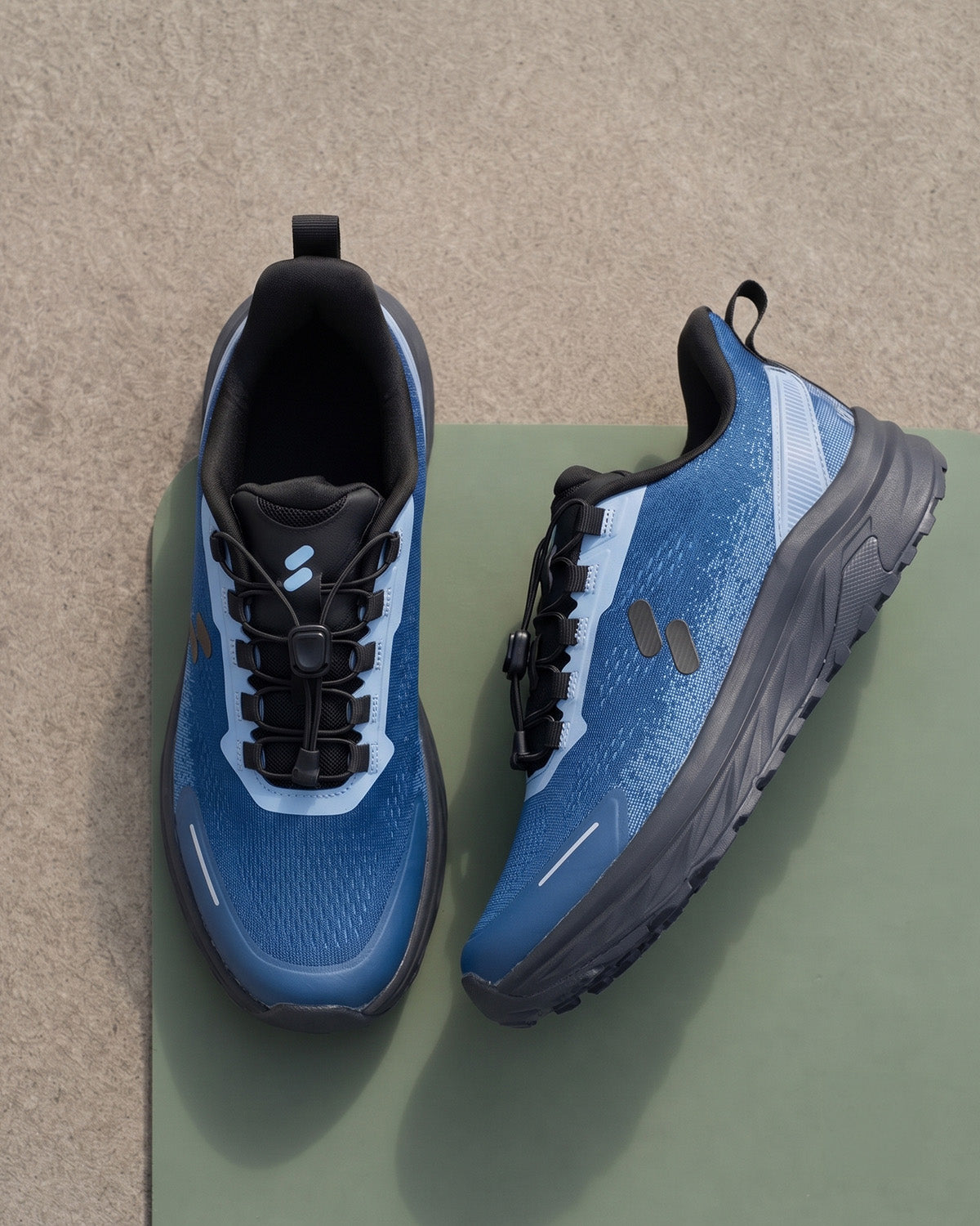 Pair of Silwer Active Ink Blue Men's Shoes on a green surface against a textured beige background