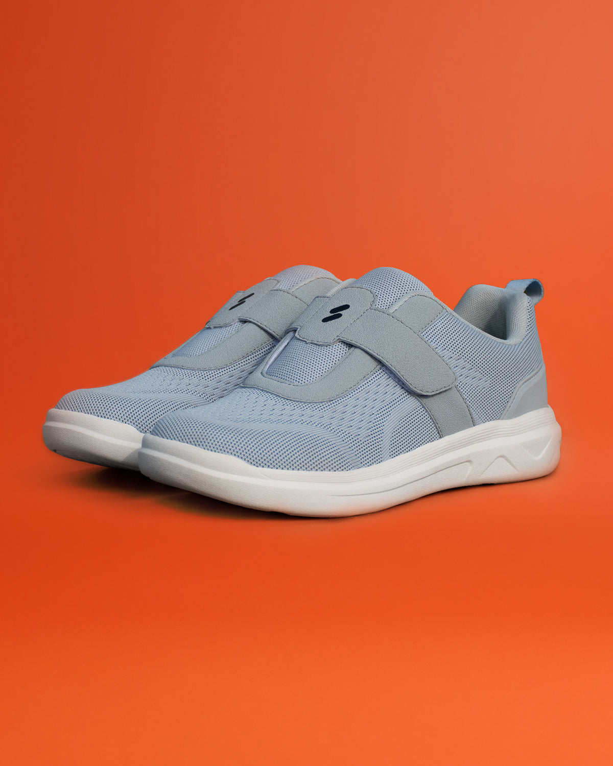 Pair of Silwer Ease Castle Grey Men's Shoes, angled view on an orange background showing the hook-and-loop strap
